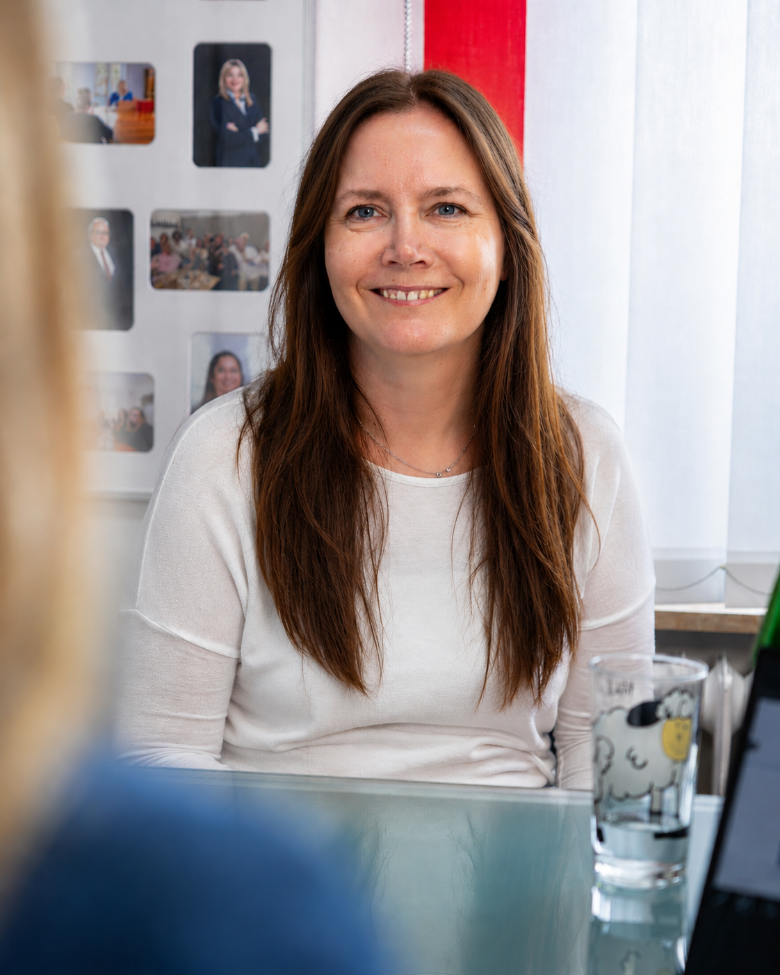 Junge Mitarbeiterin am Arbeitsplatz mit positivem Gestus